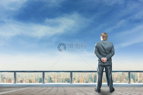 商人站在摩天大楼的顶端研究未来的地位商人展望未来图片