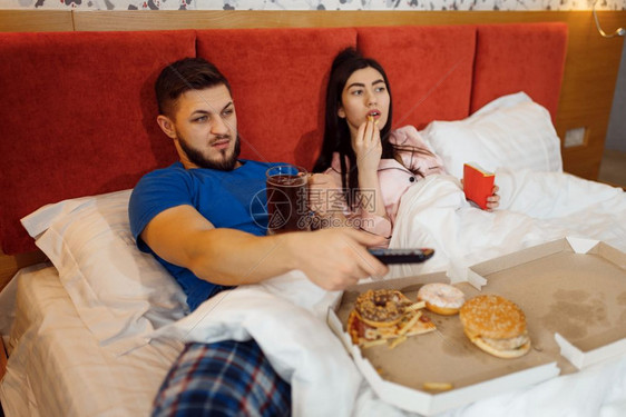 夫妻在床上吃饭和看电视图片