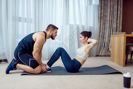 一对情侣在家中瑜伽垫上做运动图片