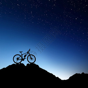 夜晚悬崖上的一辆山地自行车特写图片