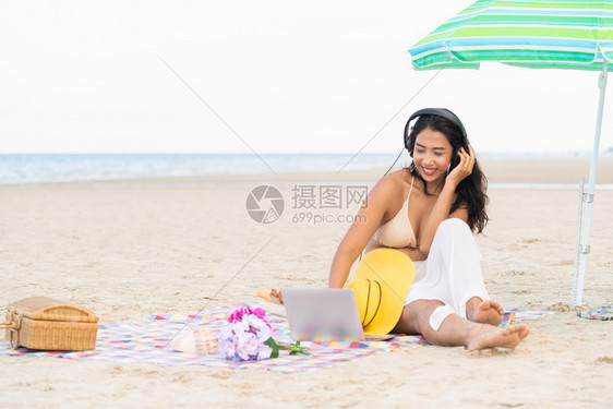 坐在海滩的年轻女子图片