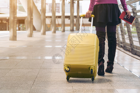 携带旅行袋或李在机场终点站行走前往国外旅的妇女者图片