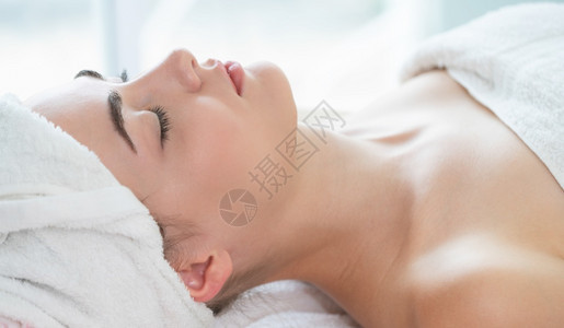 躺在温泉水疗床上放松的年轻女子图片