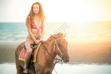 夏天在海滩骑马的时装模特图片