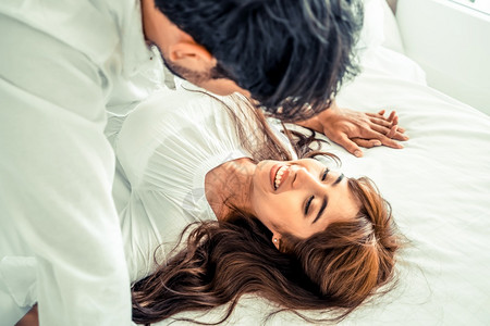爱护眼睛拥抱光明亲密年轻夫妇在床上背景