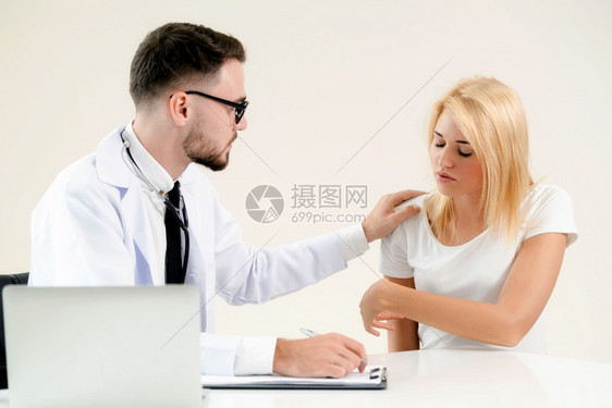 男医生与女病人交谈同时在桌子上记录图片