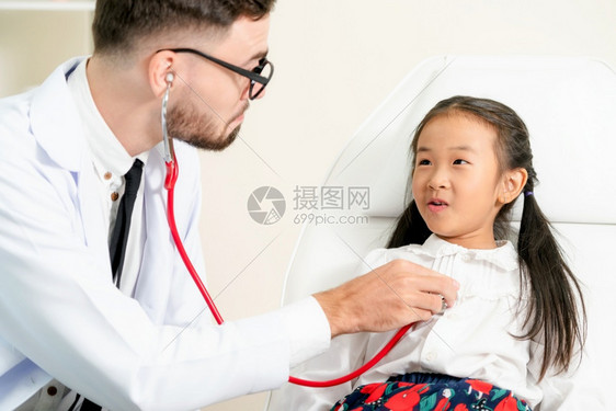年轻男医生在检查小孩子图片