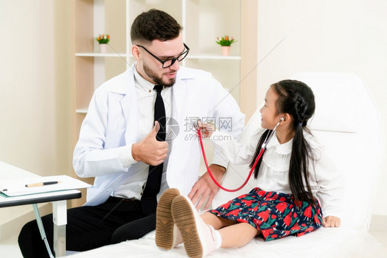 年轻男医生在检查小孩子图片