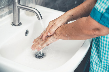 高龄妇女为预防2019年或新科罗纳疾而洗手人们在浴室水槽洗手以净化感染图片