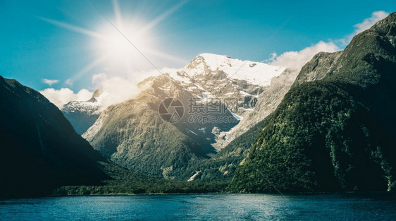 以及湖面和山地景观夏季阳光下雪峰以蓝色天空背景在密尔福德音响菲奥兰公园南新西兰岛拍摄图片