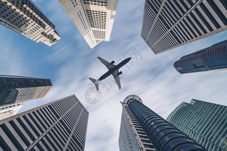 飞机在城市建筑高楼上空飞行图片