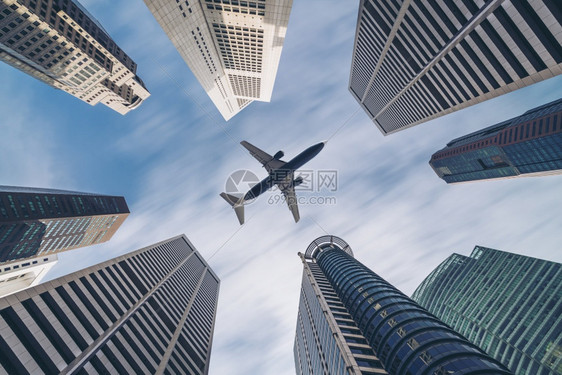 飞机在城市建筑高楼上空飞行图片