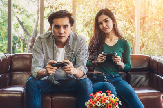 青年快乐夫妇在客厅玩电子游戏图片
