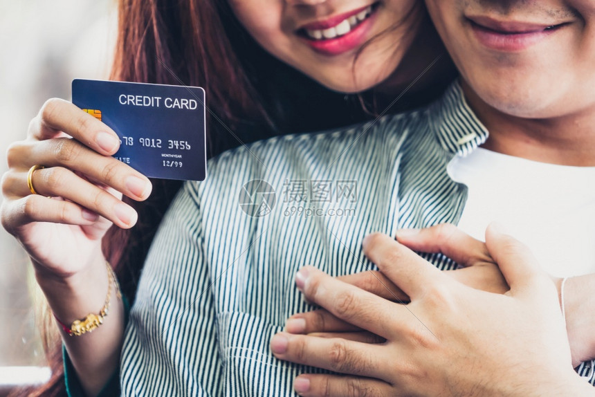 年轻夫妻使用信用卡在家中网购图片