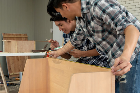 在生产建筑材料或木制家具的讲习班上从事木制工艺的的年轻图片