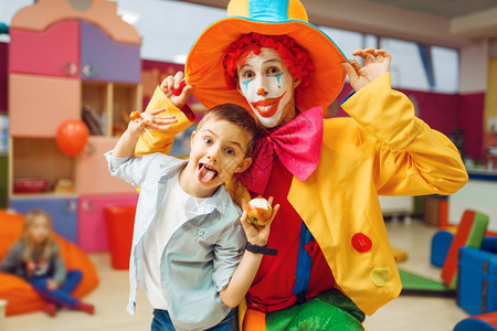 幼稚园的男孩与小丑一起互动扮鬼脸图片
