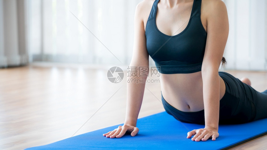女青年在室内健身房锻炼瑜伽垫子健康的生活方式和健康概念图片
