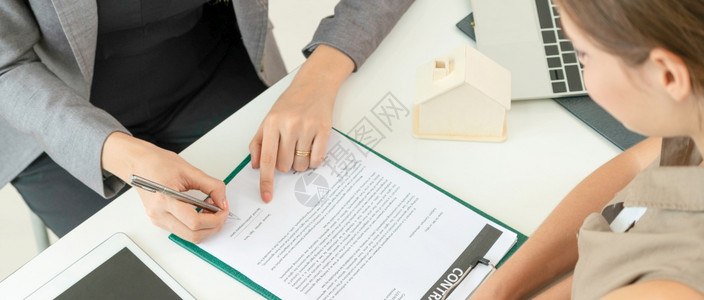 与律师或房地产代理人坐在办公桌旁的房地产活动有关的客户签名文件买卖房屋的商业概念客户签名文件以购买房屋和地产图片
