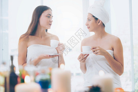 2名妇女在温泉里聊天时喝茶图片