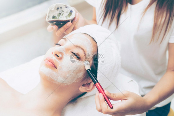 女子在健康疗养所接受美容师涂面膜图片