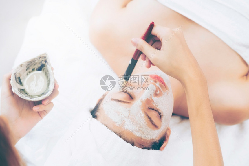 女子在健康疗养所接受美容师涂面膜图片