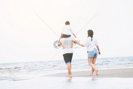 父亲母和儿子的幸福家庭夏天去热带沙滩度假图片