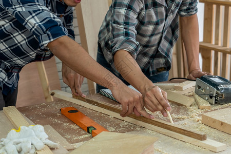 在生产建筑材料或木制家具的讲习班上从事木制工艺的的年轻图片