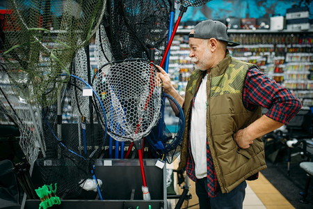 在渔场鱼钩网上选择的快乐渔夫在背景上选择网钓鱼和打猎的设备工具在商店的展品上附属选择鱼饵组合在渔场上选择网的快乐渔夫在场上选择网图片