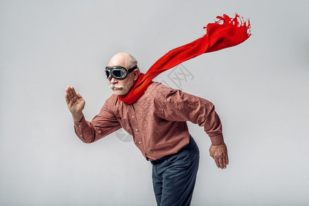 戴着红围巾的老人摆超人飞行姿势图片
