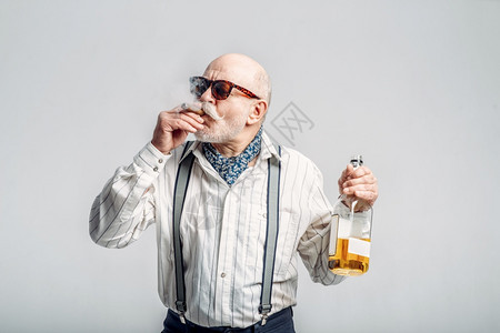 拿着一瓶好酒抽雪茄的时装老人图片