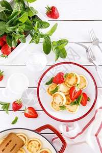 奶酪煎饼薄或配新鲜草莓和酸奶的复尼基饼薄煎或健康和美味的早餐图片