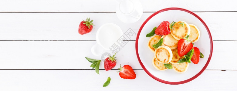 芝士煎饼薄或香肠鲜草莓和酸奶健康美味的早餐图片