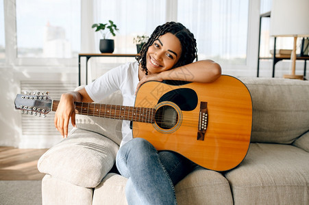 坐在沙发上拿吉他的女人图片