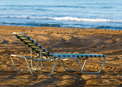 海边沙滩上的旧塑料遮晒机背景图片