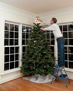 在家中装饰圣诞树的老人图片