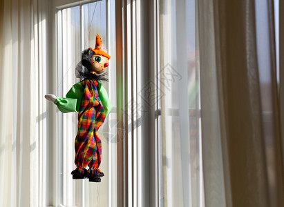 小丑玩偶木偶或挂在窗外观阳光明媚的表背景