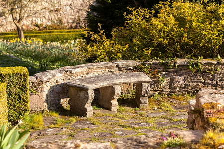 春日的阳光照射在花园里的石椅上图片