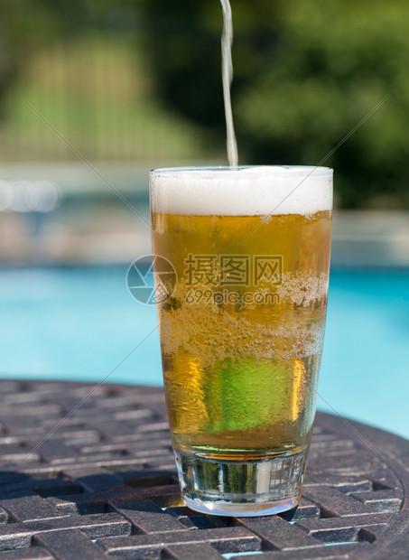 游泳池附近桌上的啤酒图片