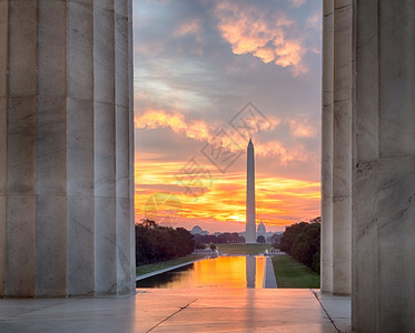 黎明时亮红和橙色的日出反射在泳池中映着华盛顿纪念碑图片