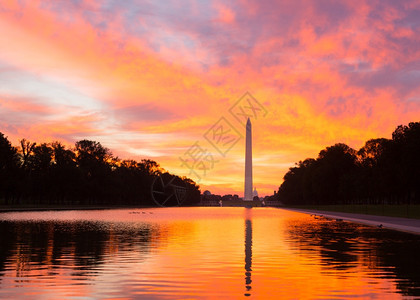 黎明时亮红日和橙色出在林肯纪念馆的新反射泳池中映着华盛顿纪念碑图片