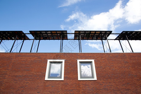 新房子的一部分有太阳能电池板有窗户和天空反射图片