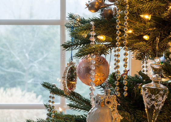 室内树上圣诞装饰的宏雪落在窗外图片