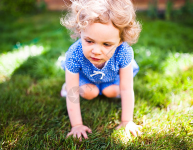 小女孩趴在草地上图片