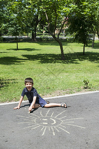 儿童在公园沥青上晒太阳画画图片