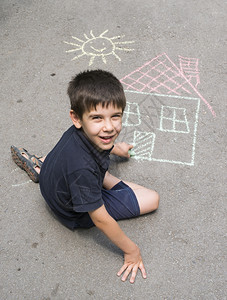 儿童在公园沥青上晒太阳画画园沥青上画日光和房屋图片