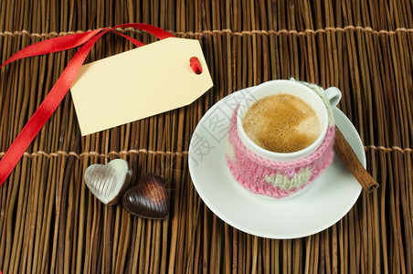 咖啡杯有编织的心脏符号和标签在木制底座上图片