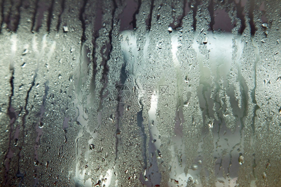 由湿风挡玻璃和雨滴构成的背景图片