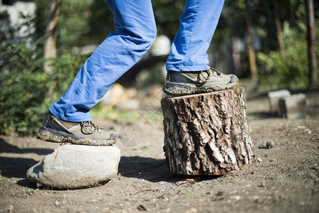 棕色徒步鞋在森林的树桩上图片