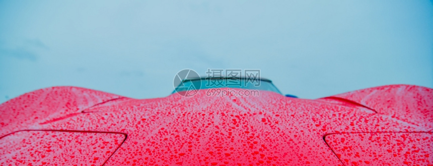 炫酷红色跑车被雨湿润的特写镜头图片