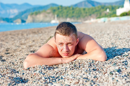 躺在岩石海滩上的人日光浴图片